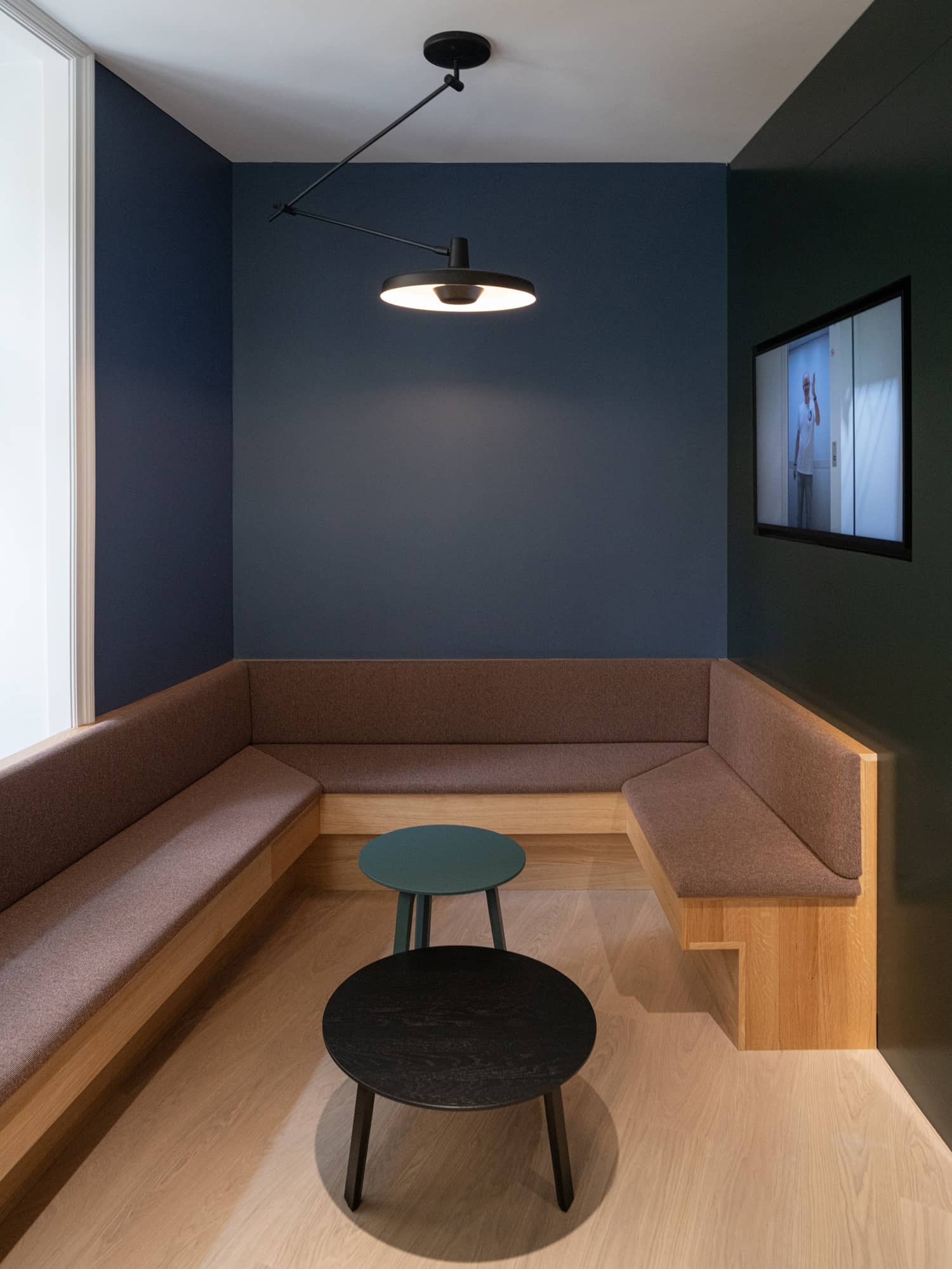 Eine grosse Sitzecke mit Sitzb&auml;nken sowie einer blauen und einer gr&uuml;nen Wand